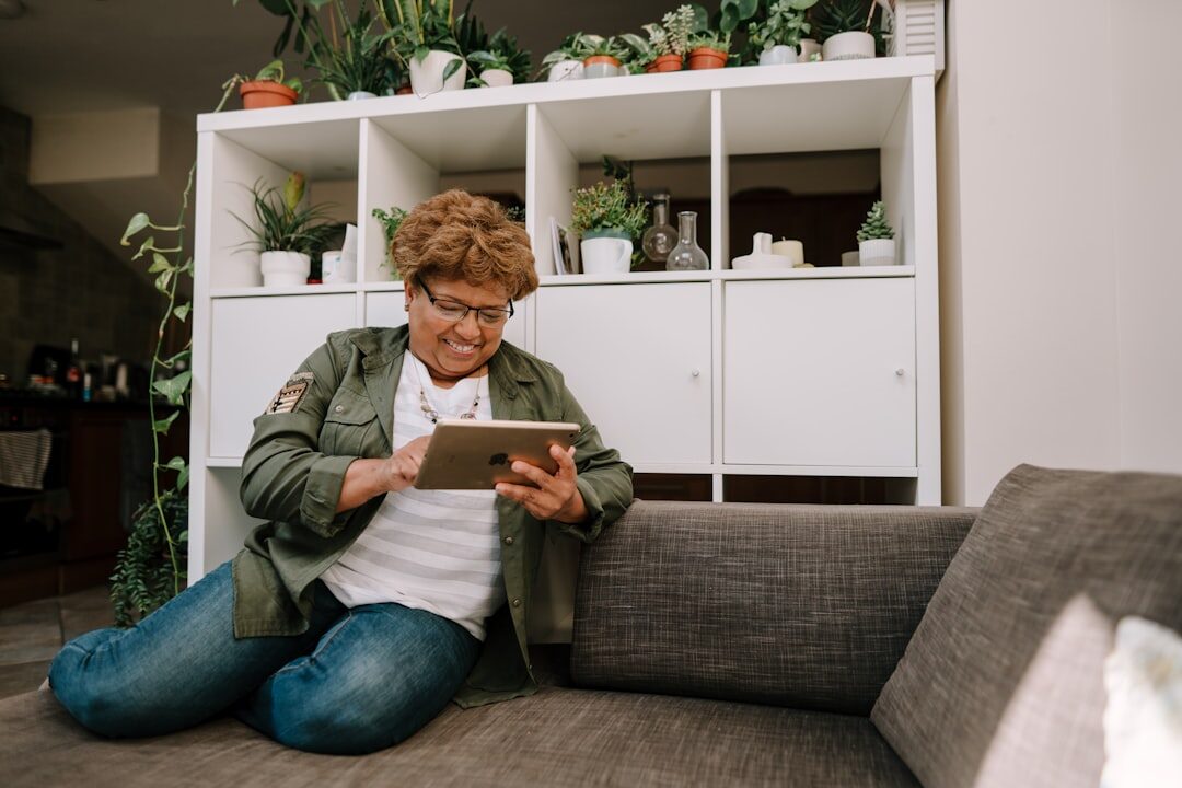Senior Croatian woman smiling while using a tablet at home
